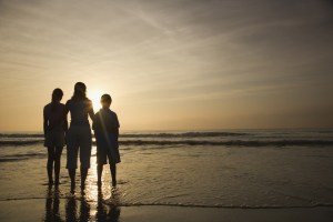 Silhouette of three family members at beach